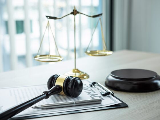 Judge gavel with Justice at law firm in background with legal case document contract