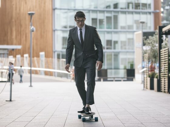 Handsome young business man with his modern longboard