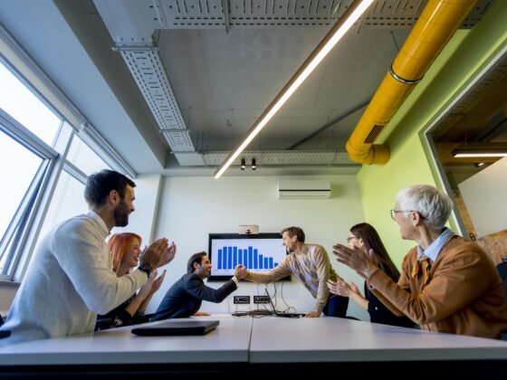 Young businessman presenting project strategy showing ideas on interactive whiteboard in office